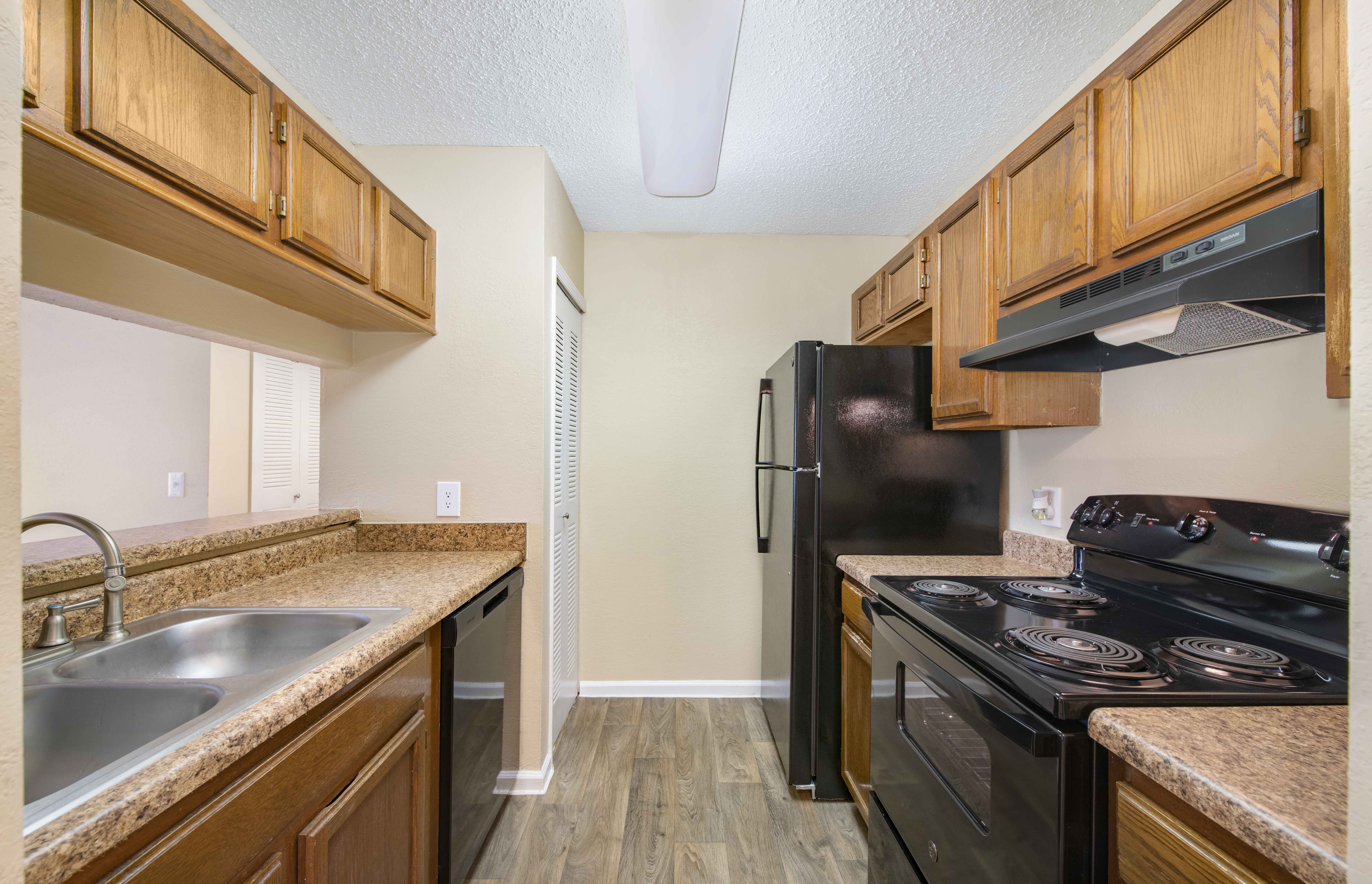 a kitchen with a stove refrigerator and sink