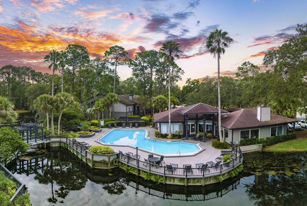 an aerial view of a swimming pool at a resort with palm trees