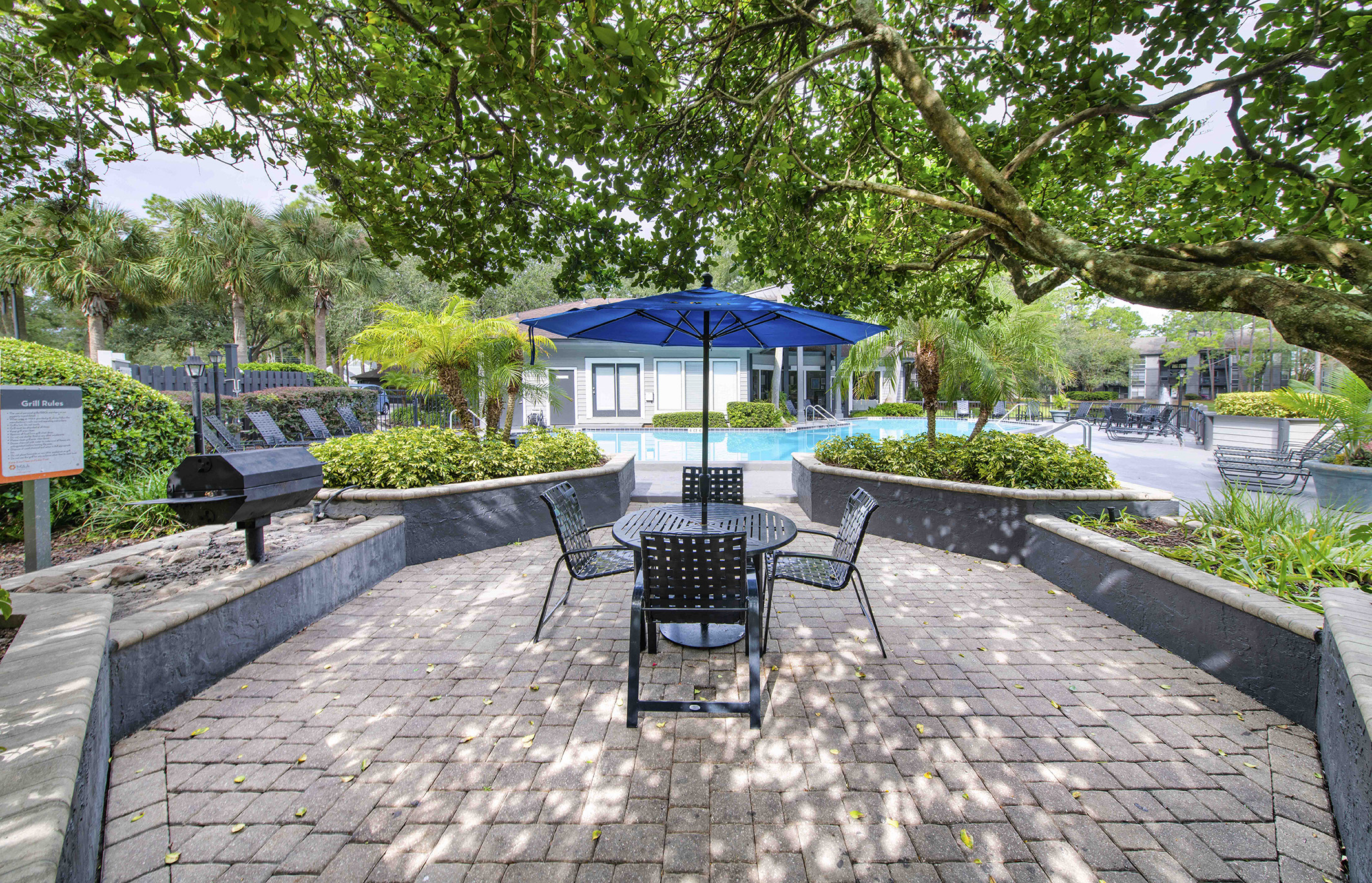 a patio with a table and chairs next to a swimming pool
