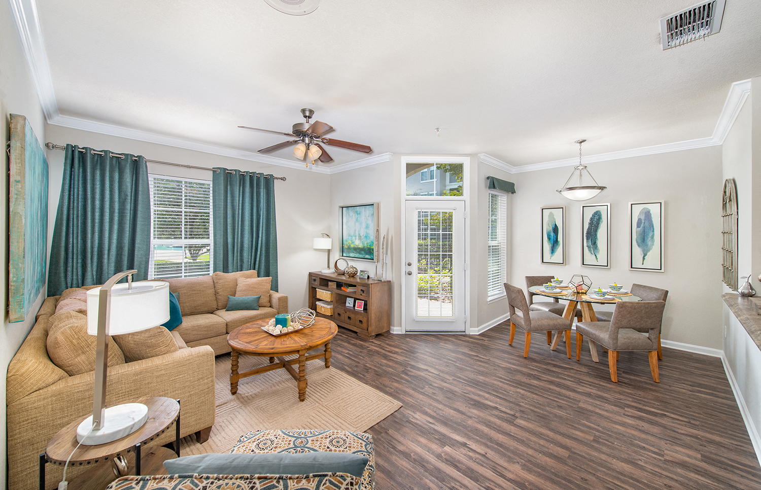 a living room with a couch and a table and a ceiling fan