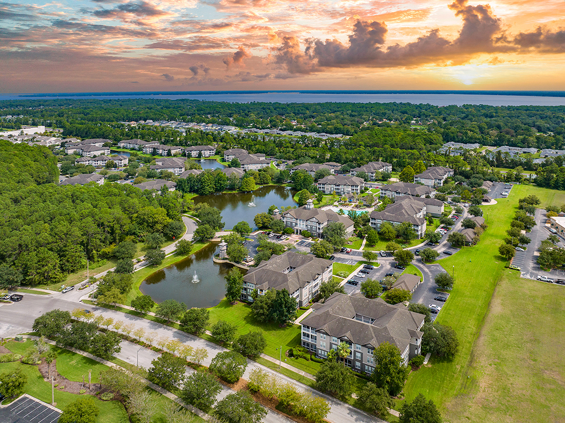 an aerial view of a neighborhood with a lake and houses