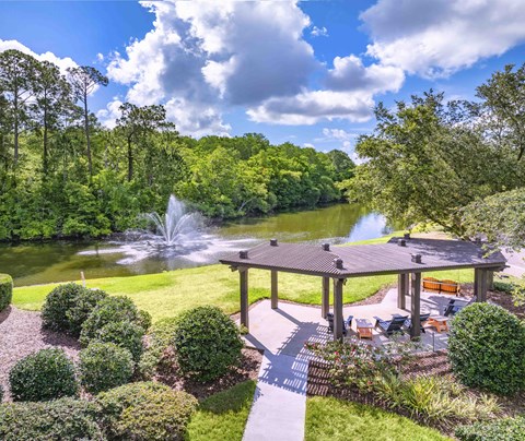 a backyard with a pond and a gazebo and a fountain