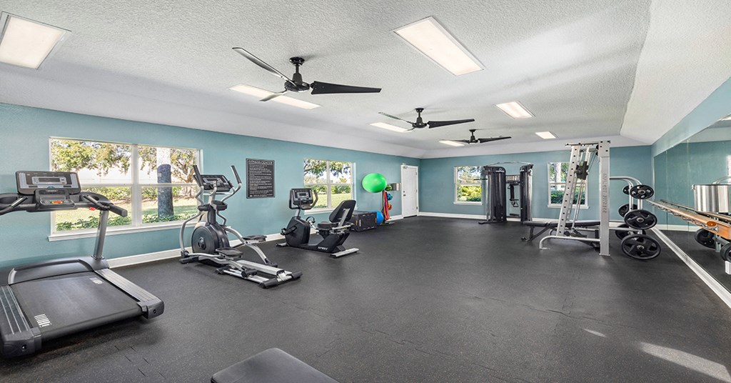 A spacious gym with treadmills, exercise bikes, and other equipment.