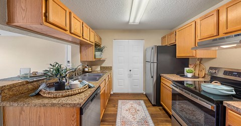 A kitchen with wooden cabinets and a black refrigerator.