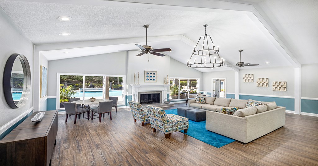 A spacious living room with a fireplace and a large mirror on the wall.