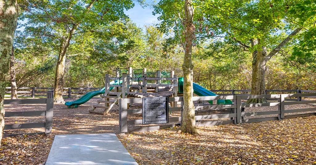 A playground with a slide and a signboard.