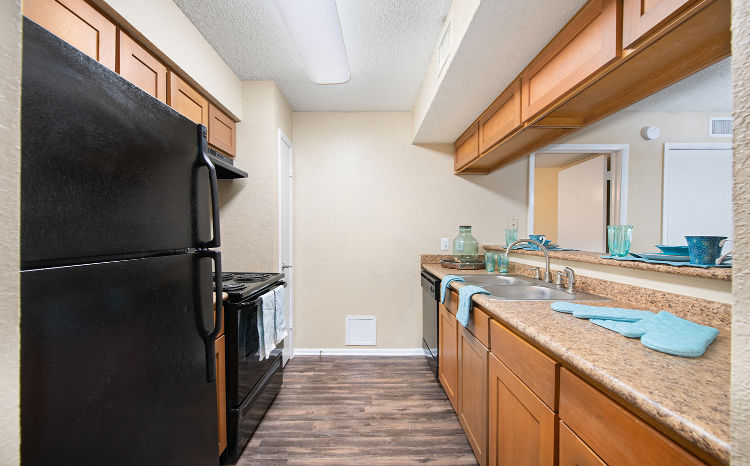 a kitchen with a black refrigerator and a sink