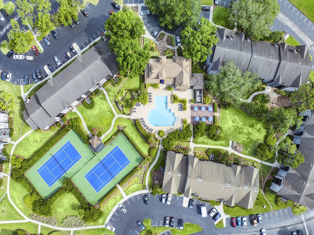 a birdseye view of a neighborhood with a tennis court and a pool