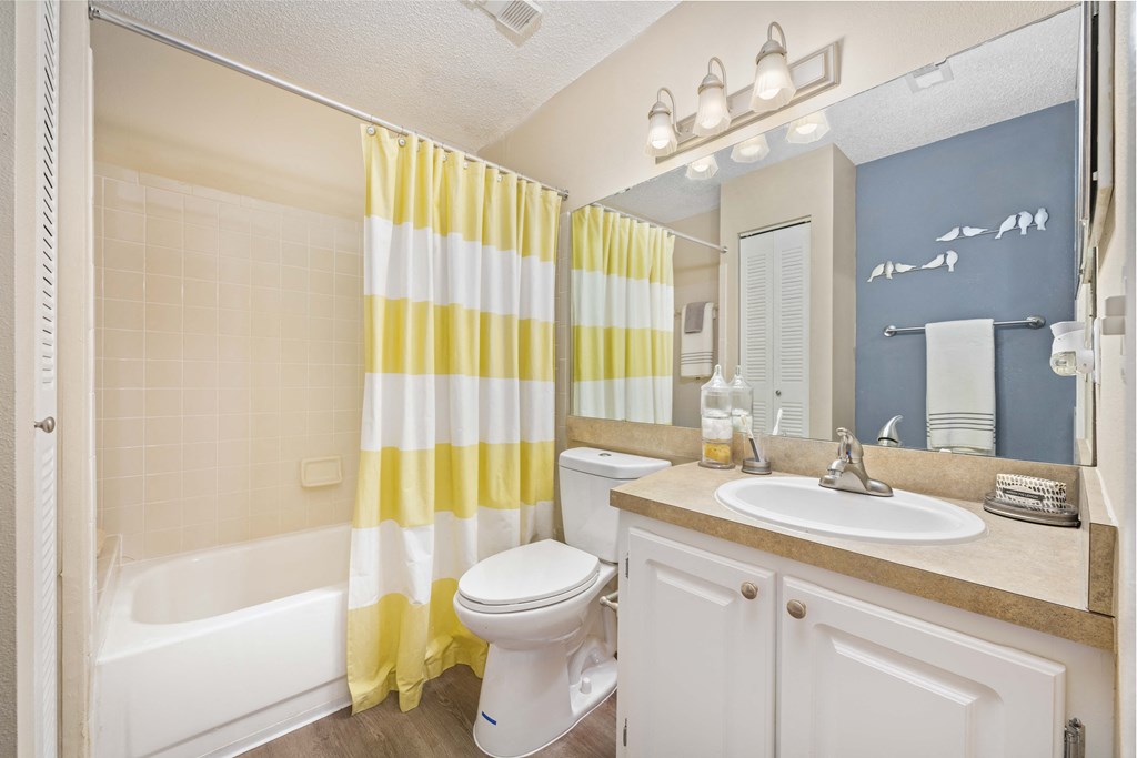 a bathroom with a yellow and white shower curtain