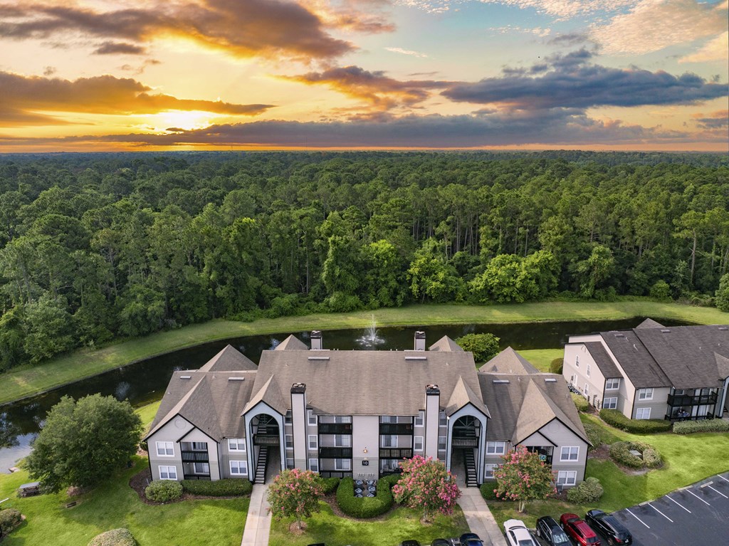 an aerial view of a house with a sunset behind it