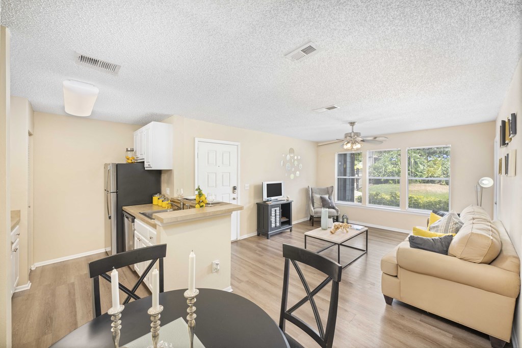 the living room and kitchen of an apartment with a couch and a table