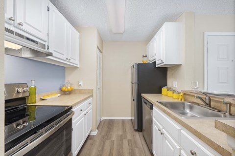a kitchen with stainless steel appliances and white cabinets