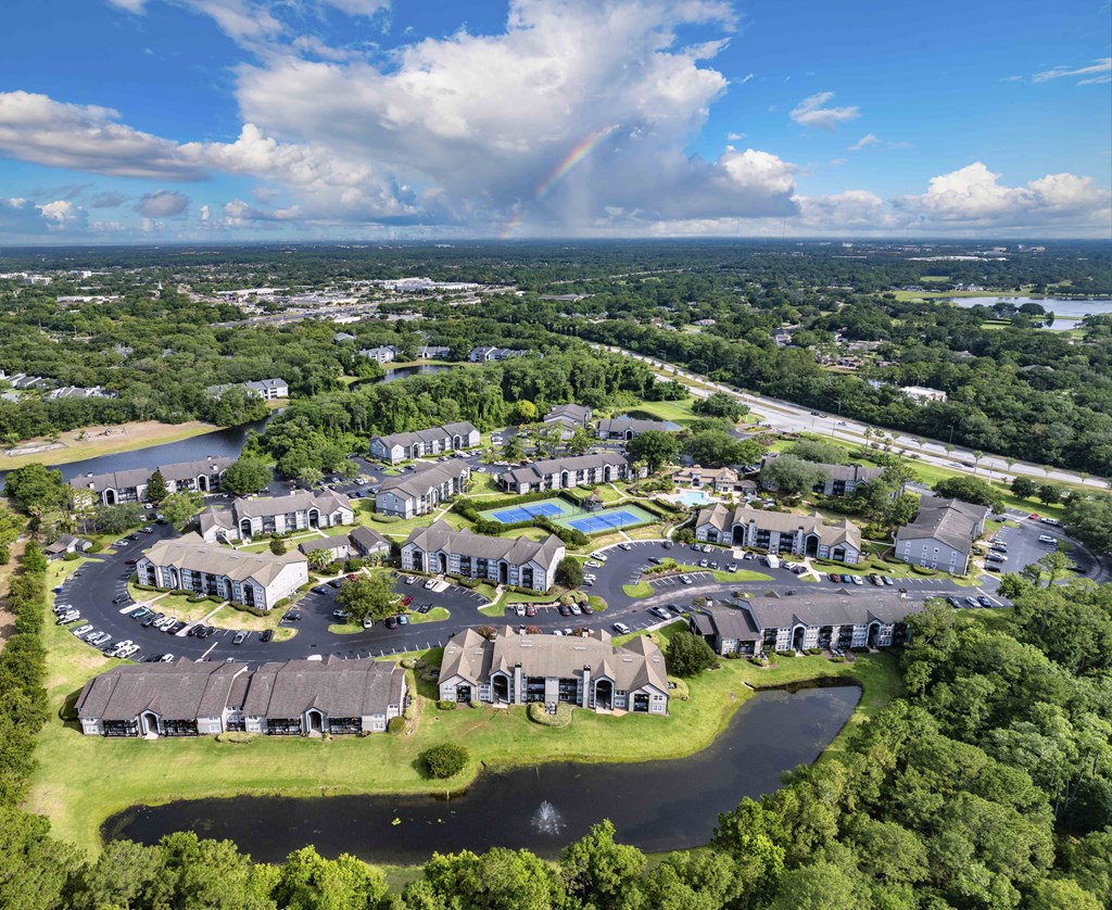 an aerial view of an apartment complex with a rainbow in the distance