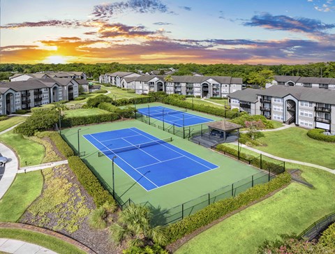 an aerial view of a tennis court with apartments in the background