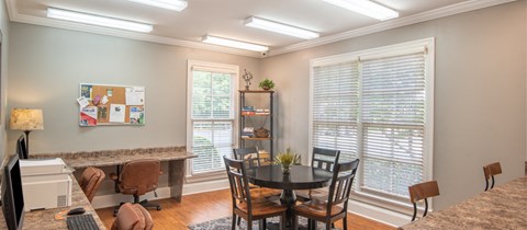 a dining room with a table and chairs and two windows