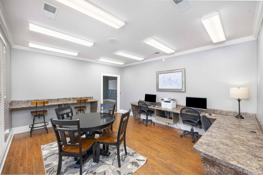 A modern home office with a desk, chairs, and a computer setup.