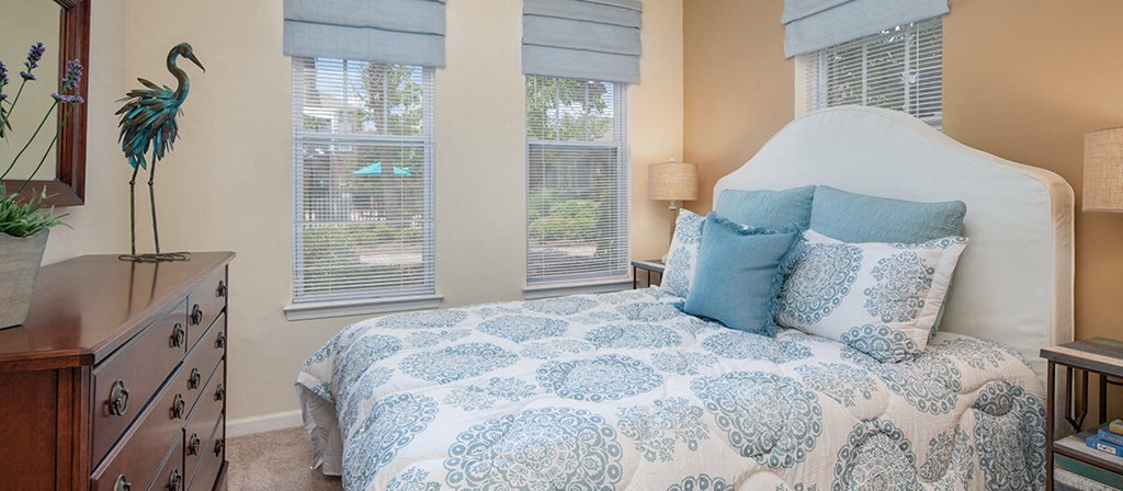 a bedroom with a bed and three windows