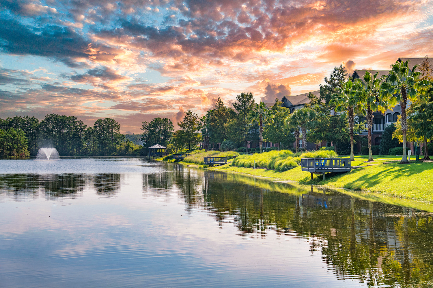 a sunset over the water at a resort with a fountain
