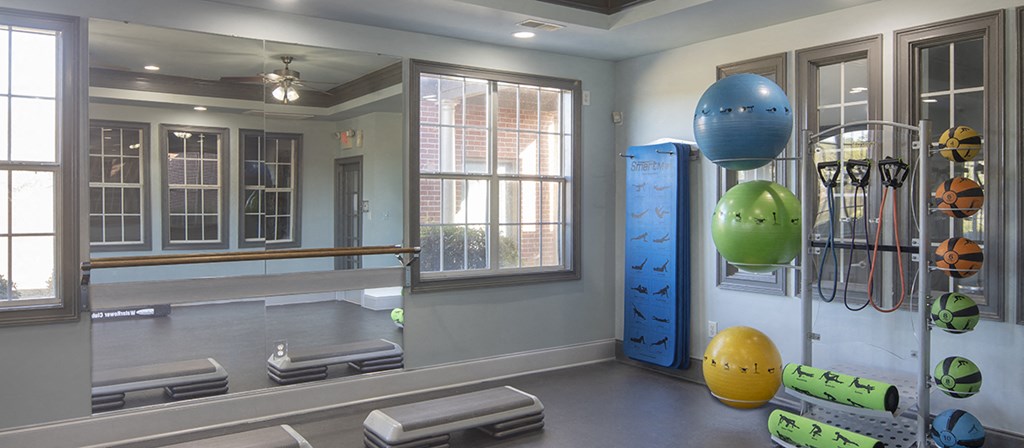 a fitness room with exercise equipment and a window