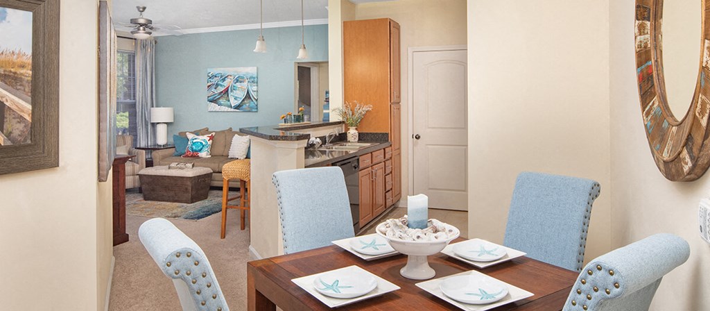 a living room and dining room with a table and chairs