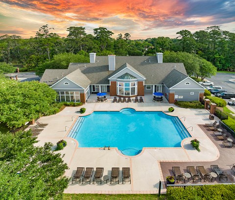 an aerial view of a pool and a house with a swimming pool
