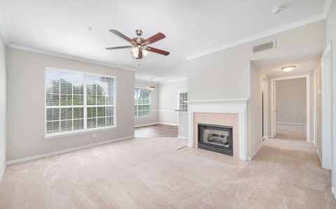 a living room with a fireplace and a ceiling fan