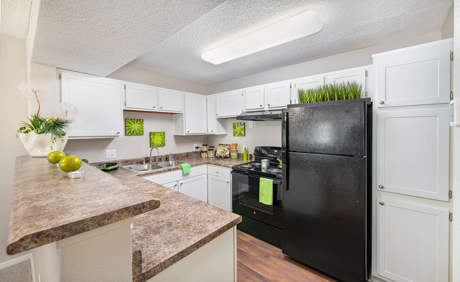 a kitchen with white cabinets and a black refrigerator