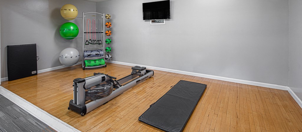 a yoga room with yoga mats on the floor and a treadmill