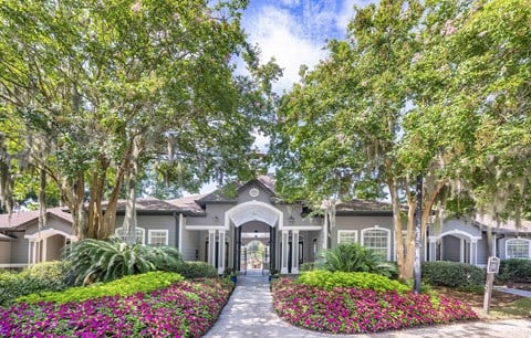 a house with trees and flowers in front of it
