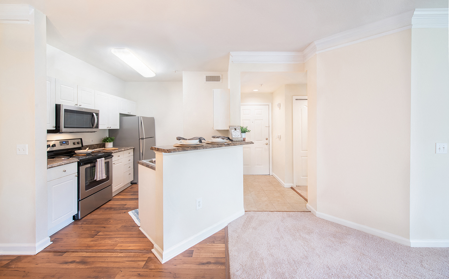 a renovated kitchen with white cabinets and stainless steel appliances