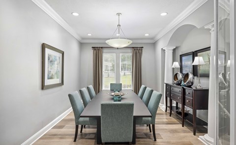 A dining room with a long table and chairs.