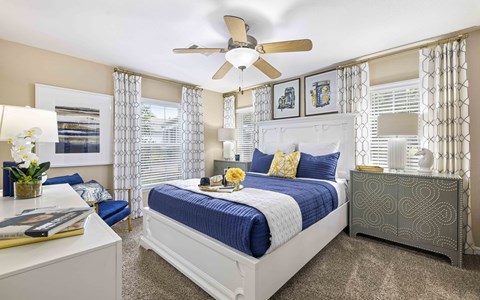 A bedroom with a bed, nightstand, and a ceiling fan.