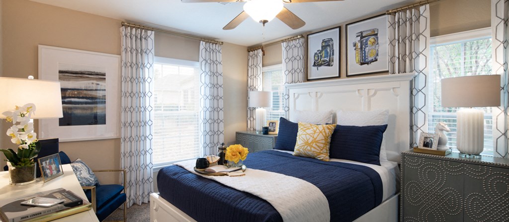 a blue and white bedroom with a bed and windows