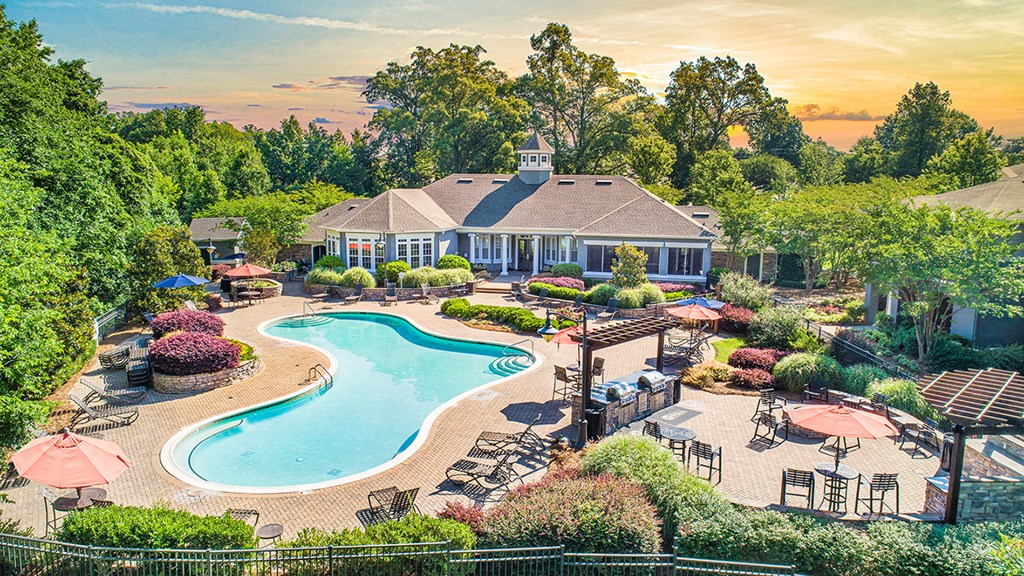 an aerial view of a pool and backyard with a house