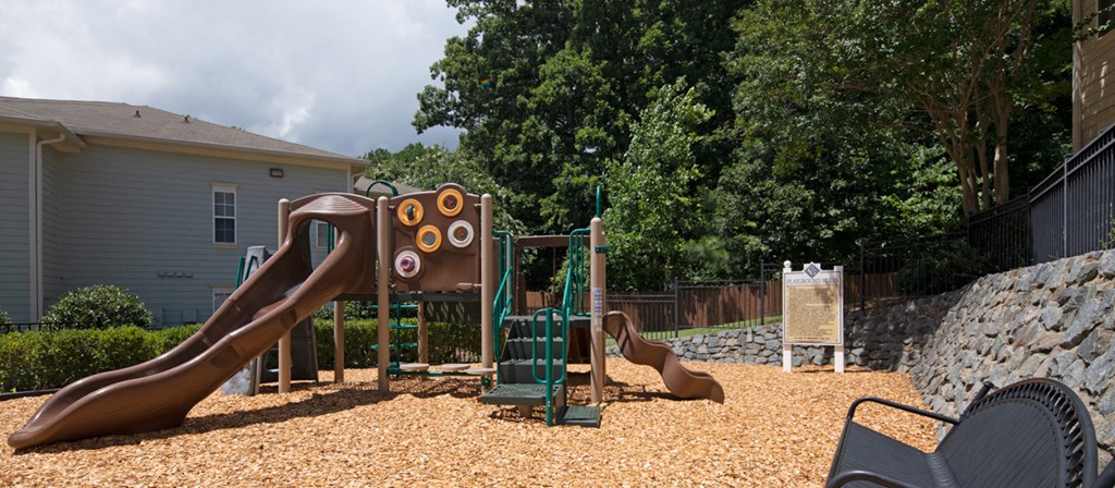 a playground with a slide and other toys in a backyard