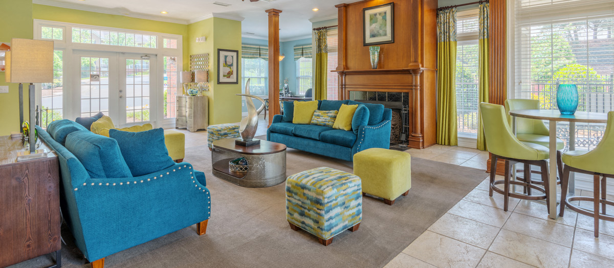 a living room with blue couches and chairs and a fireplace