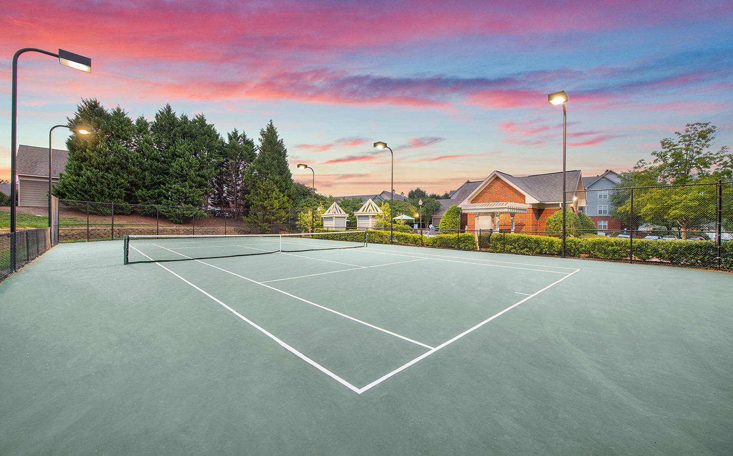 the tennis court is equipped with lights for night playing
