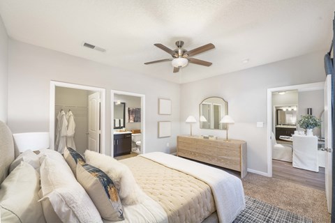 A bedroom with a large bed and a ceiling fan.