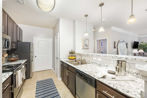 A kitchen with a black fridge and a white sink.