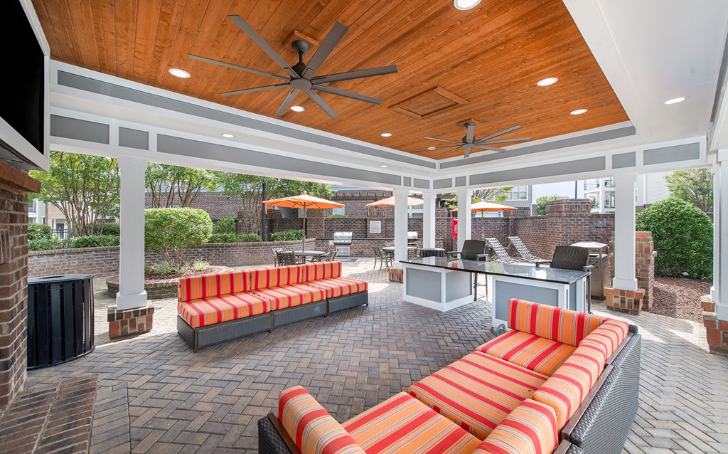 a covered patio with couches and a bar