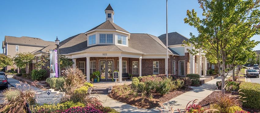 the front of a building with a porch and a sidewalk
