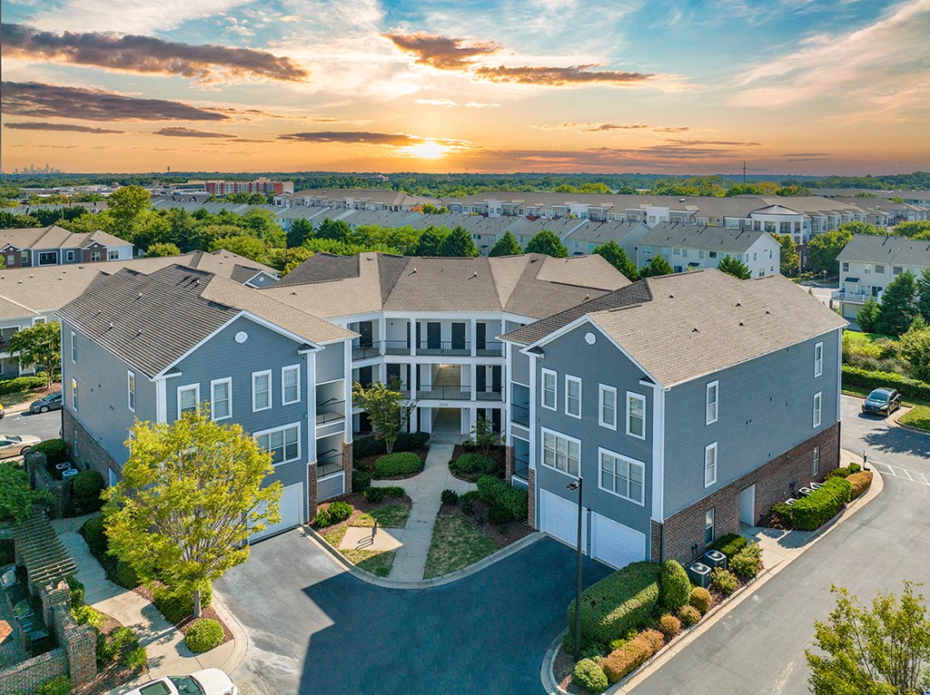 an aerial view of an apartment building with a sunset in the background