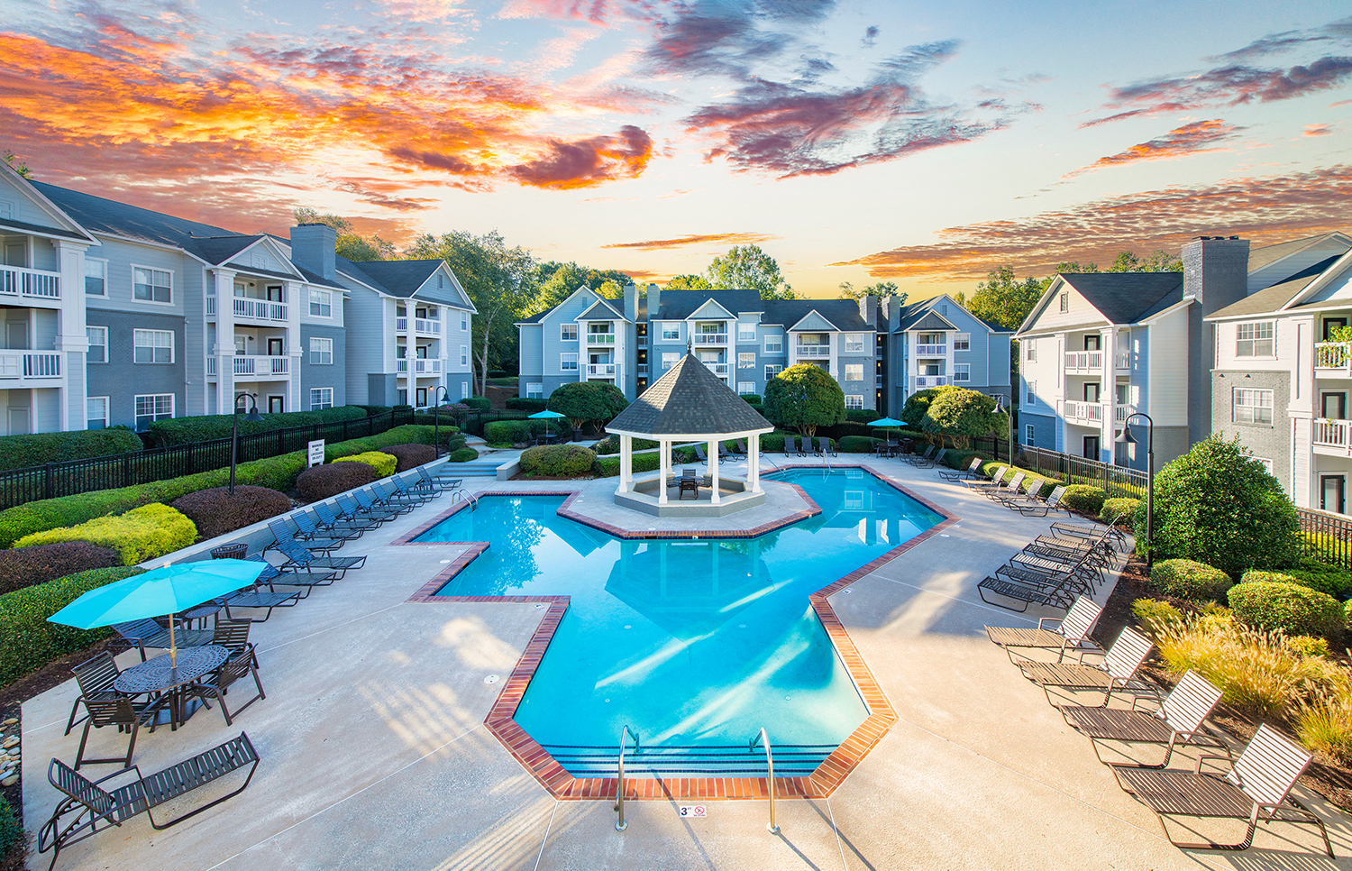 an aerial view of a swimming pool with chairs and umbrellas at the resort