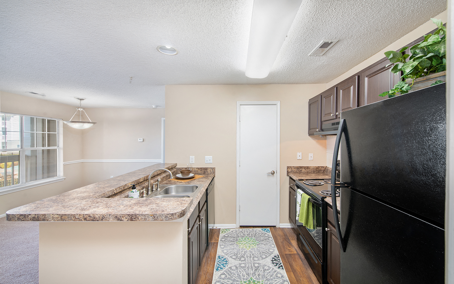 an updated kitchen with black appliances and granite counter tops