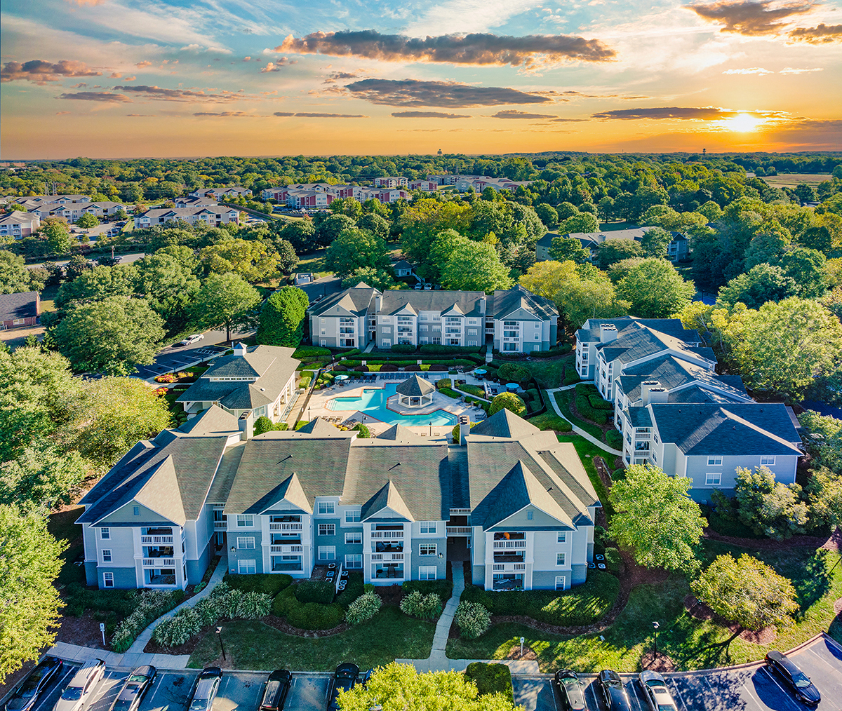 a aerial view of a house with a swimming pool in the middle of a neighborhood