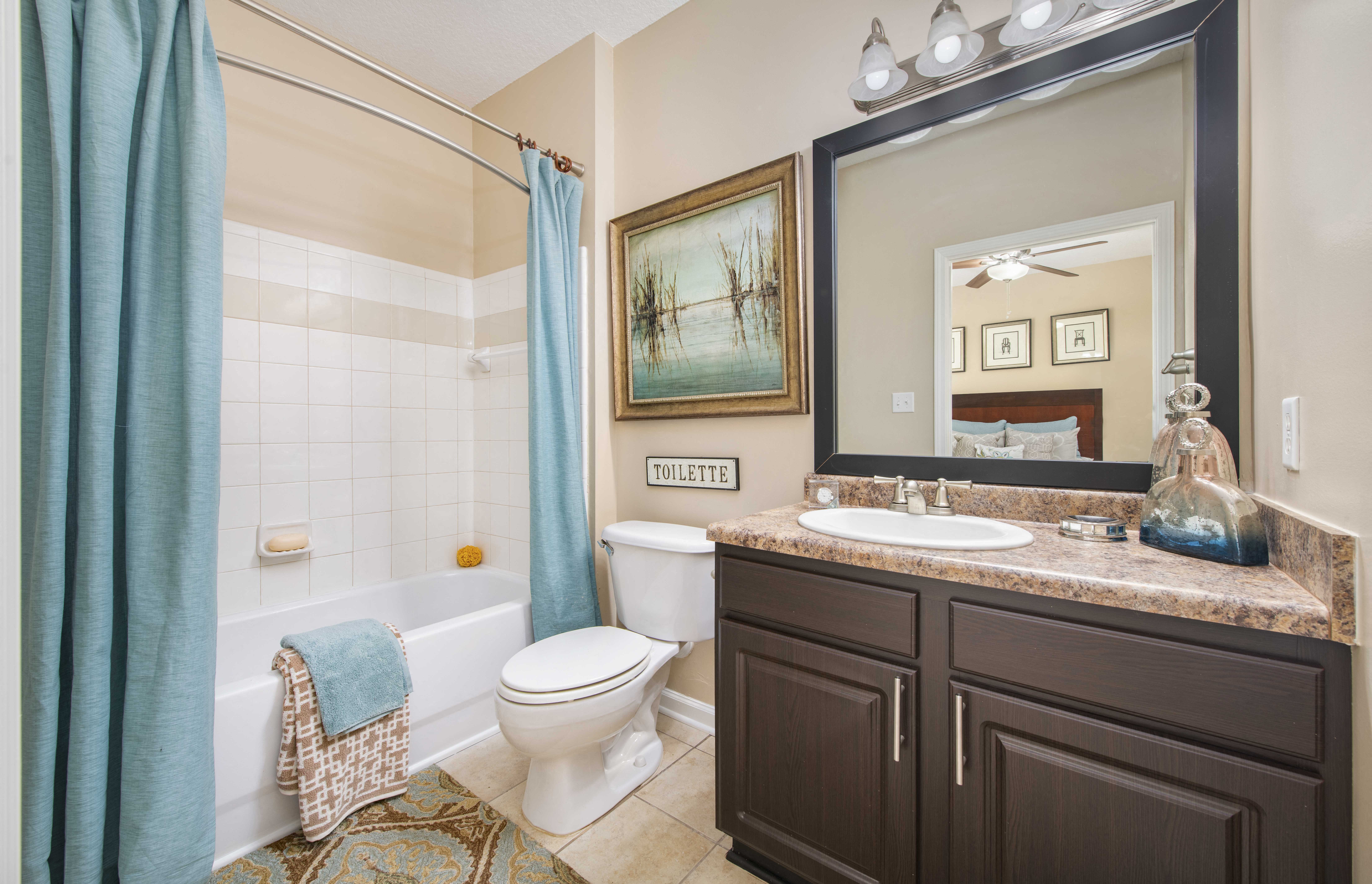 a bathroom with a shower toilet and sink and a mirror