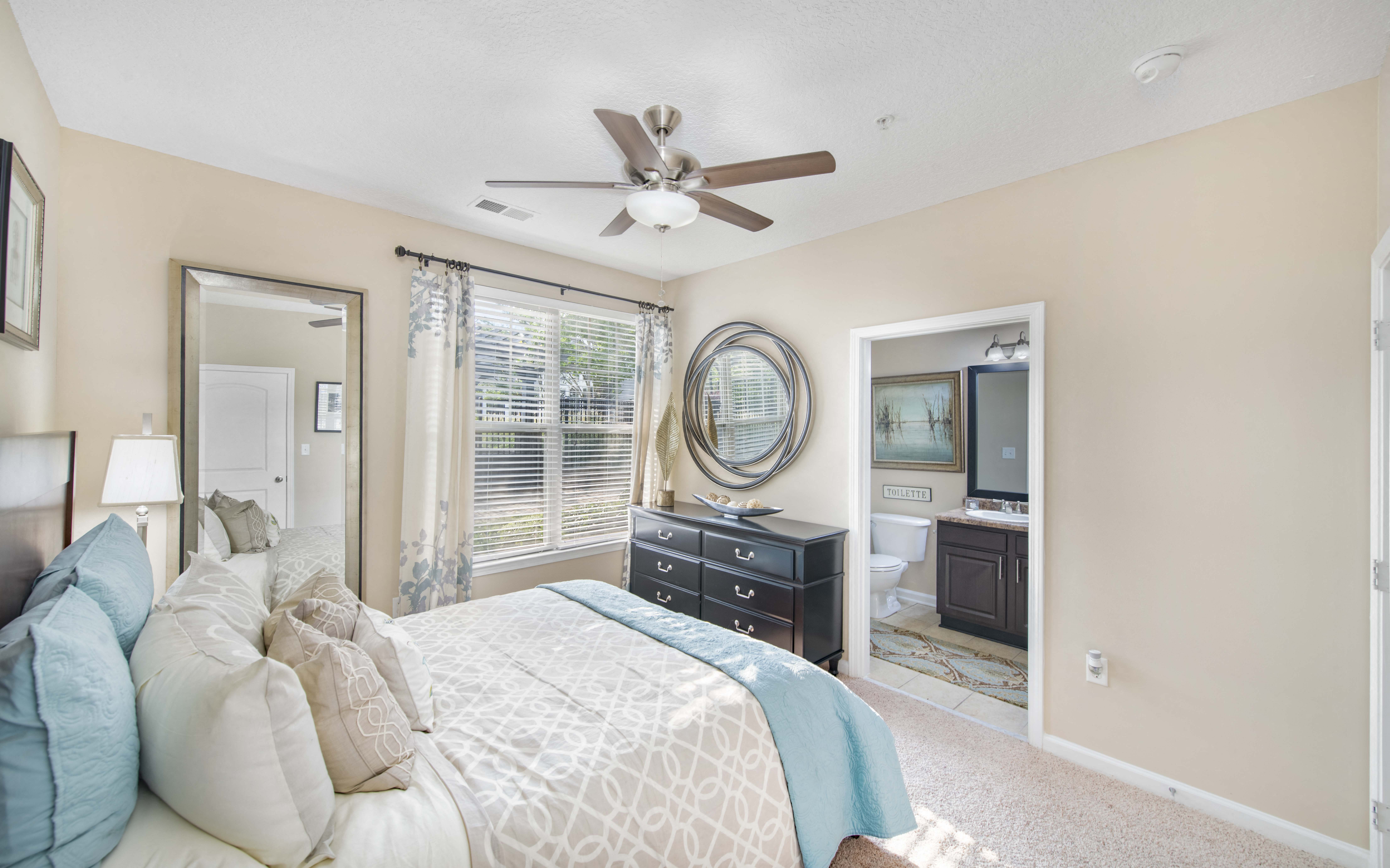 a bedroom with a large bed and a ceiling fan