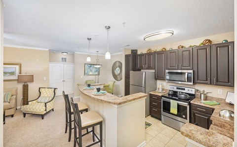 A kitchen with a refrigerator, oven, and sink.