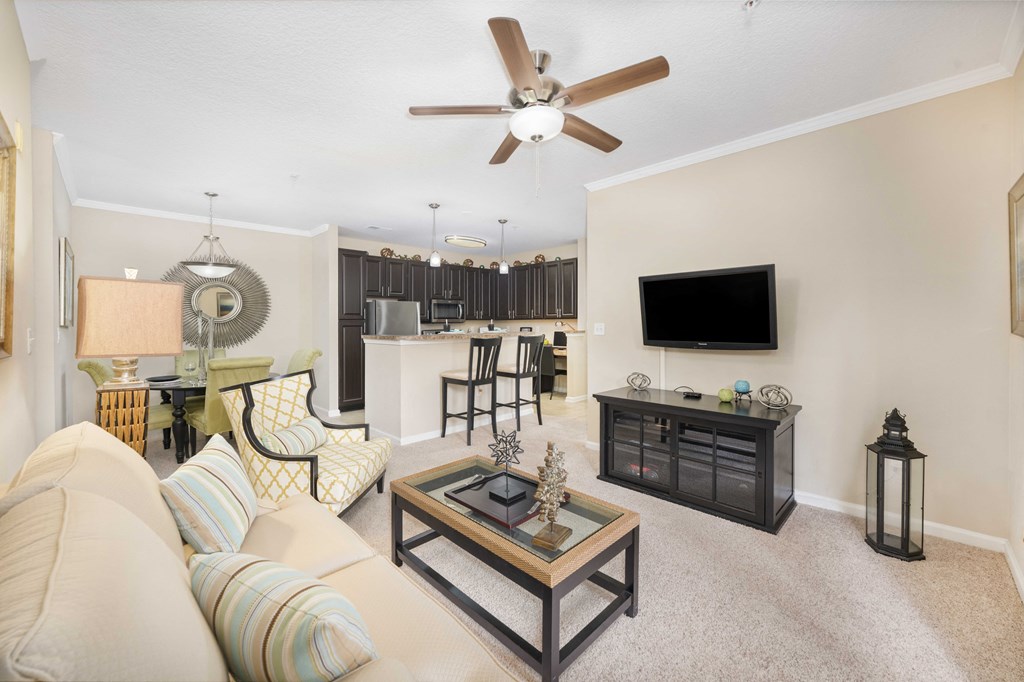 A living room with a beige couch and a black coffee table.
