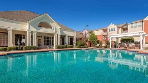 a large swimming pool with apartments in the background